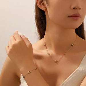 Gold evil eye jewelry set with crystal necklace, bracelet and earrings on model