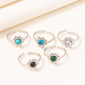 Detailed view of adjustable stainless steel rings featuring vintage sunburst and gemstone inlay