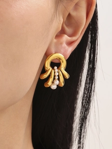 Close-up of gold layered earrings with pearls on model, featuring liquid metal design