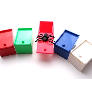 Detail of colorful prank boxes with a realistic black spider jumping out of the red lid