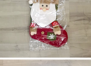Détail de chaussette de Noël Père Noël sous emballage sur carrelage gris
