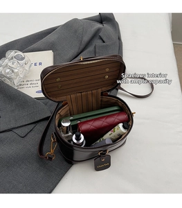 Detail shot of the spacious vintage box bag interior with wallet, perfume, and phone