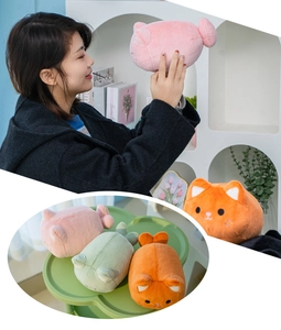 Close-up of cute plush cat keychains in pink, green and orange with soft texture