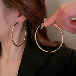 Minimalist large golden hoop earrings for women with elegant metallic finish in a classic round style