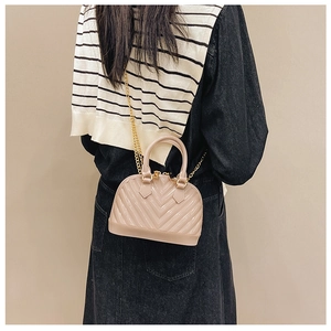Detailed back view of a beige shell jelly bag with V-shaped quilting and gold chain strap
