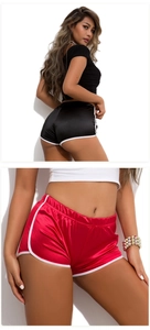 Detail of satin sports shorts in black and red with contrast white piping and elastic waistband
