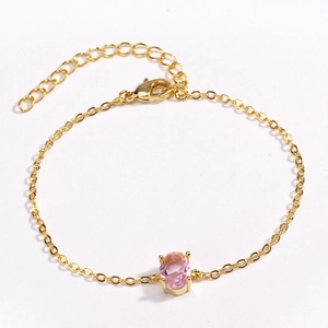 Detailed view of a gold-plated bracelet with a pink oval zircon and lobster clasp closure