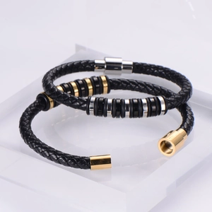 Detail of black woven leather bracelets with gold and silver magnetic steel clasps