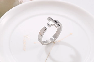 Detail of silver cross open ring displayed on a decorative Cancer constellation dish