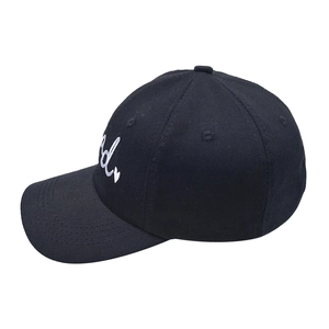 Close-up of white letter d and heart embroidery on a black cotton baseball cap