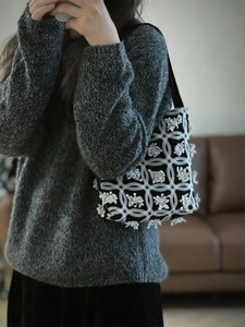 Detail of bohemian black and white crochet handbag with 3D floral embroidery textures