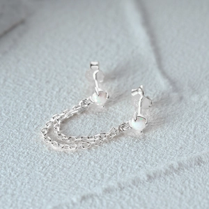 Macro detail of S925 sterling silver chain earrings with opal stone and hallmark