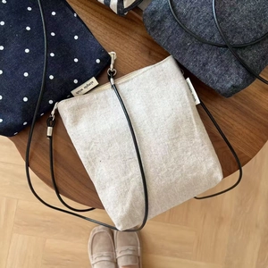 Detail view of cotton-linen crossbody bags with simple wish labels and rope straps