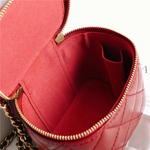 Macro view of the red quilted leather bag interior with gold chain and zip details