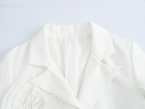 Detail of elegant white blazer lapel featuring a 3D floral decoration and refined stitching