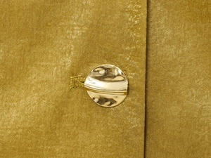 Dettaglio ravvicinato di bottoni metallici dorati su elegante tessuto mercerizzato