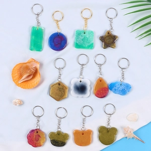 Flat lay of colorful resin keychains in heart and star shapes with seashell decorations
