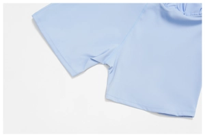 Close-up of flatlock stitching and stretch fabric on light blue pleated tennis skirt