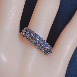 Detailed view of a triple row zircon ring with classic claw setting on a silver band