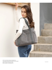 Modern grey canvas tote bag shown on shoulder in a minimalist outdoor setting