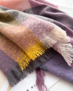 Close-up of multicolor plaid scarf showing soft faux cashmere texture and fringe detail