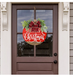 Detail of red and wood Merry Christmas door wreath with checkered bow on glass door
