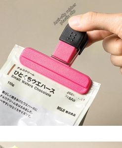 Pink T-shaped food sealer clip with wide anti-slip rubber head on plastic snack bag
