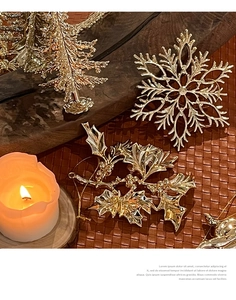 Detailed close-up of golden Christmas snowflake and holly ornaments on dark wood background