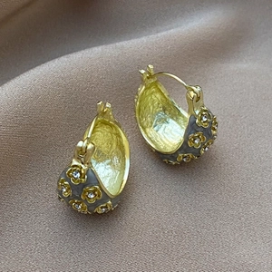 Macro shot of retro flower earrings with grey enamel and sparkling cubic zirconia