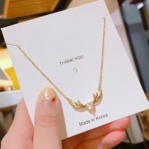 Collar de reno minimalista con colgante de circonita corazón en tarjeta de exhibición