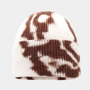 Macro detail of tie-dye knit beanie showing textured ribbed patterns and brown dye