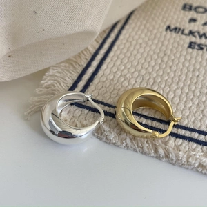 Polished 925 sterling silver teardrop earrings in gold and silver finishes on fabric