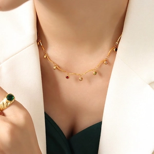 Ensemble collier et bague dorés à l'or 18 carats avec zircons colorés porté par mannequin