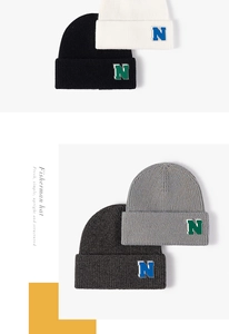 Detail view of four-color knit beanies featuring textured ribbing and N letter patch