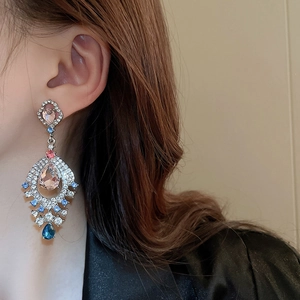 Macro detail of fan-shaped drop earrings with colorful crystals and silver needles