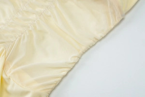 Detail of yellow mesh fabric and elastic pleated stitching on the summer dress