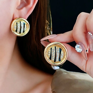 Vintage round gold-toned earrings with black stripes and sparkling crystal accents
