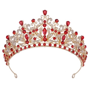 Macro detail of luxury gold crown featuring red gems and sparkling crystal rhinestones