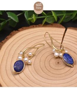 Close-up of vintage gold wire-wrapped earrings with blue lapis and natural pearls