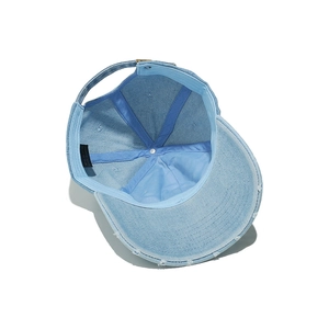 Detailed inner view of light blue washed denim baseball cap with reinforced seams