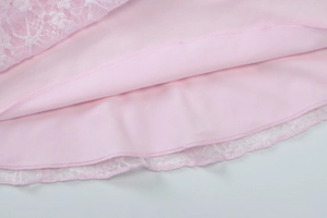 Gros plan de l'ourlet rose avec dentelle blanche délicate et détails de couture précis
