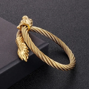 Détail macro d'une tête de dragon dorée et texture torsadée sur un bracelet en acier
