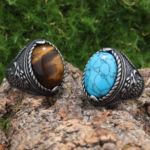 Retro stainless steel rings with tiger eye and turquoise stones on tree bark texture