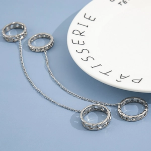 Silver punk style Cuban chain rings set with linked metal chains on blue background