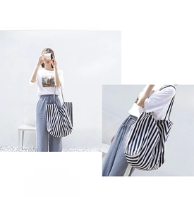 Detail of blue and white vertical striped canvas tote bag with large capacity design