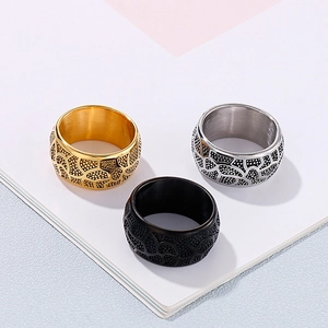 Detailed view of three vintage stainless steel rings with black textured engravings