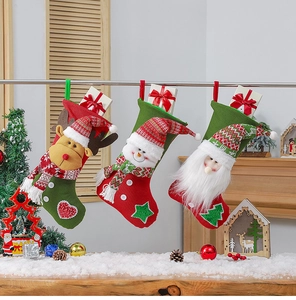 Close-up of three knitted Christmas stockings with reindeer, snowman and Santa plushies