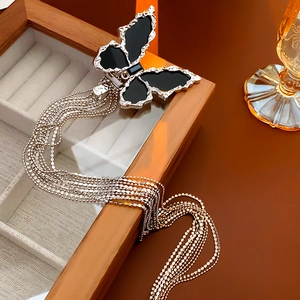 Close-up of black butterfly hair claw with silver tassels and metallic finish details