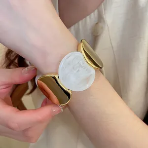 Bracelet élastique en acrylique avec métal doré et design rond à texture marbre