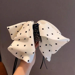 Polka dot bow hair claw clip for high ponytail made of glossy silk fabric in white and black